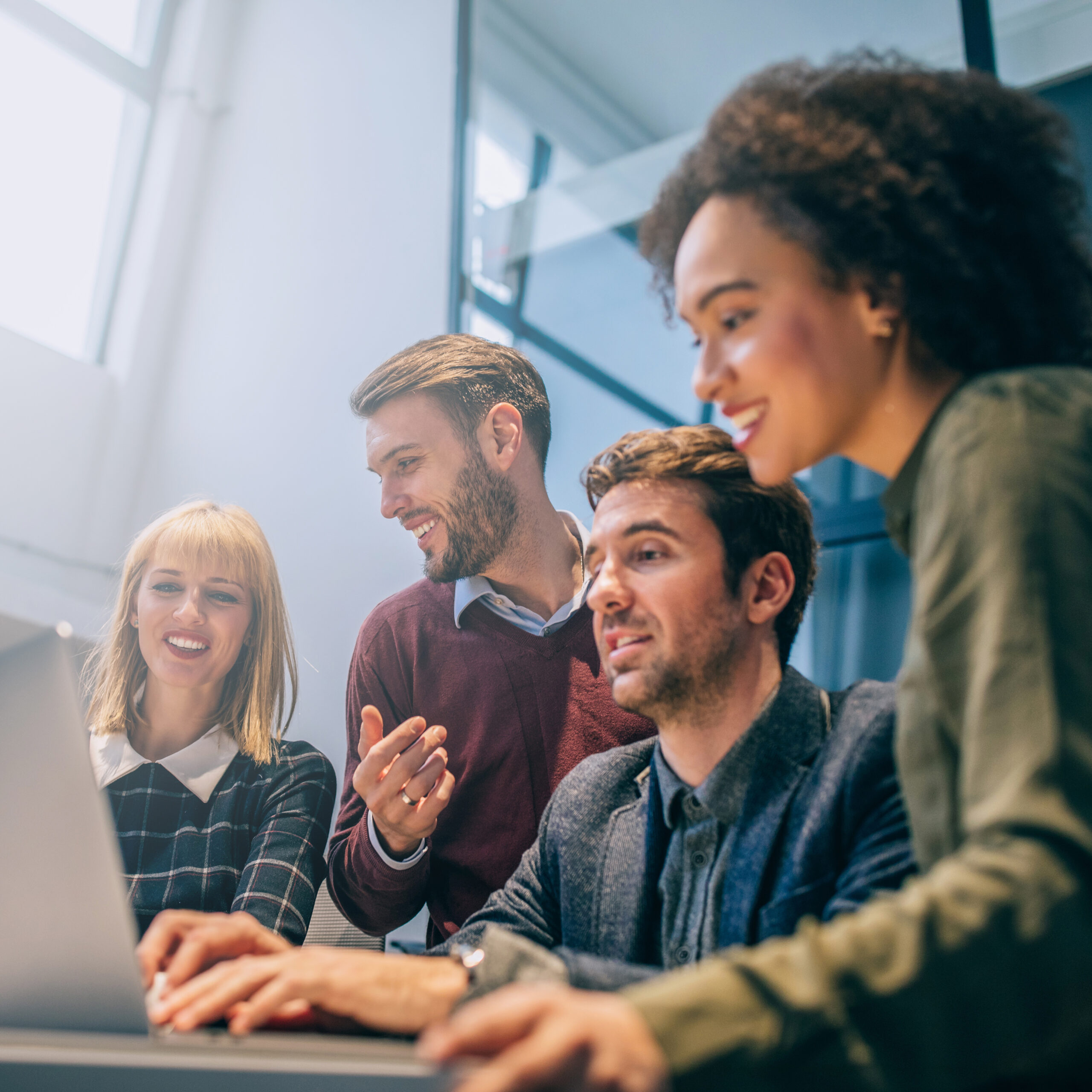 Shot of a group of coworkers discussing something while looking at a laptop computer